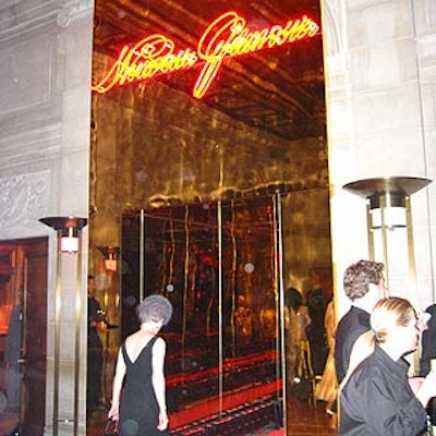 A neon 'Nouveau Glamour' sign atop a gold mirrored hallway decorated the entrance.