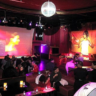 A large white projection screen was suspended above the stage, and Fila-branded signage hung in an elevated seating area.