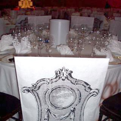 Touches of bohemian glamour—like white chair covers decorated with a sketch of an ornate chair—added to the romantic La Boheme-inspired decor.