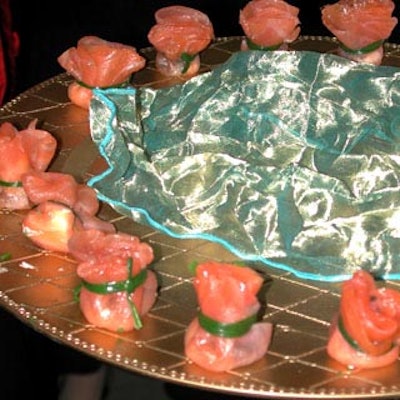 Great Performances served caviar wrapped in smoked salmon tied with scallion on gold platters decorated with pieces of blue organza.