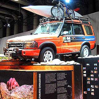 The Range Rover showed off its off-road prowess with a towering display that featured its SUV on a bed of rocks, splattered with mud, and loaded down with a bike and kayak on the roof rack.
