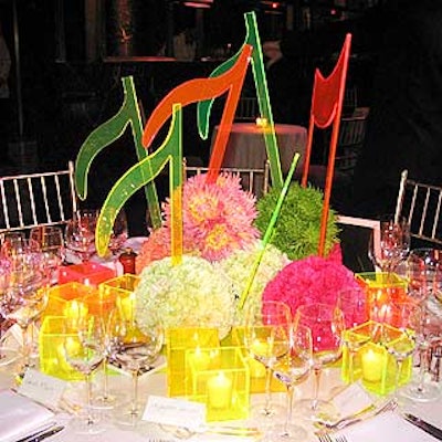 Jane Packer used neon musical notes made out of Lucite, flowers arranged in spheres and square Lucite candleholders.
