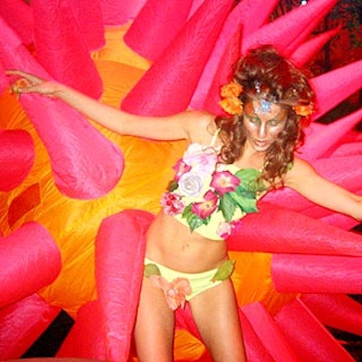 A 'sexpot' dancer dressed in a lime green bikini covered with faux flora from the Mystic Family Circus danced with a performer inside a pink and orange sea urchin costume from Hollywood Pop Gallery.