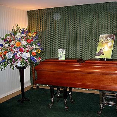 A blowup of the book cover and traditional funeral flowers adorned the casket at the party.