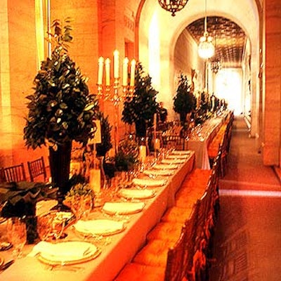 One long row of tables created a communal-style dining area, which was decorated with large antique sterling silver candelabras and mixed greenery centerpieces.