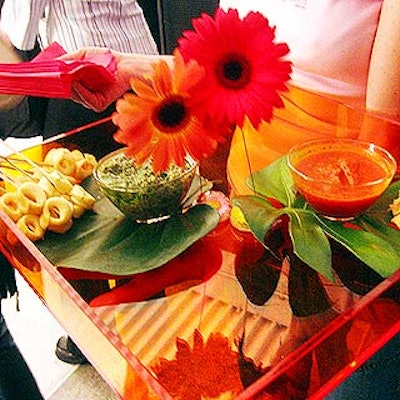 Match Catering and Eventstyles' neon Lucite trays were decorated with lush green leaves and bright gerbera daisies.