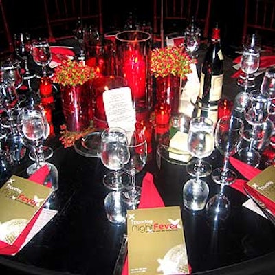 Bronson Van Wyck covered the tables with silver mylar and decorated them with glass cylinders, orchid and red rose arrangements, floating blossoms and candles.