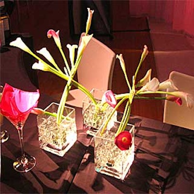 Starbright Floral Design weaved together pink and white calla lilies from different square vases to link the arrangements.