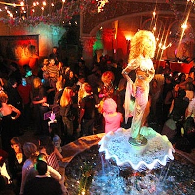A crowd of fashion followers filled the venue's 'Opening Night Party' room, where a wax figure of RuPaul—who sang 'Supermodel,' remember—stands above a water fountain.