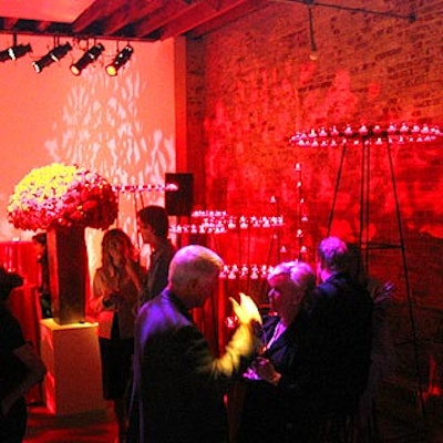 Avi Adler used large red flower arrangements, red lighting and large votive candle holders in one corner of the studio space in Industria Superstudio.