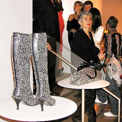 A pair of boots and a purse with the black-and-white 'Game' pattern were displayed on white tables.