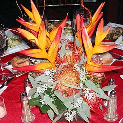Terrastacio decorated tables with red tablecloths and floral arrangements with fiery orange, red and yellow colors.