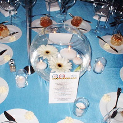 Musters & Company used floating white gerbera daises and white votives in glass fishbowls for the table centerpieces.
