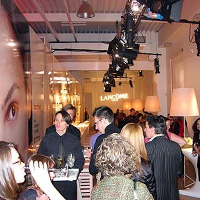 The long, narrow third room featured blowups of Lancome's advertisements behind a long white bar running along the wall. Small, stretch fabric-covered tables paired with large lamps sat opposite the bar, where Lancome reps demonstrated how the new color-matching technology matches the foundation to the client's skin.