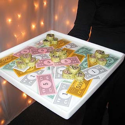 Hors d'oeuvres—such as grilled Thai beef wraps—were served in lucite trays decorated with Monopoly money.