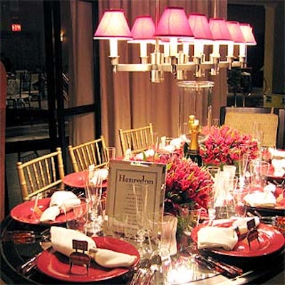 Interior designer David Easton adorned furniture company Henredon's table with large arrangements of red tulips, red plates and a chandelier decked with small red lampshades.