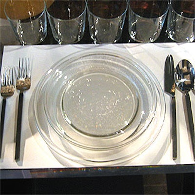 Glass plates, skinny flatware and a row of tumblers at each place setting added to the minimalist look of the Levi's table.
