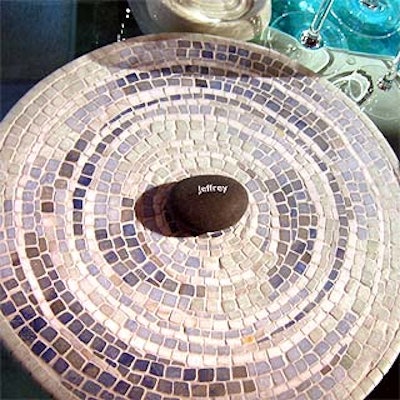 Polished pebbles embossed with guests' names helped them find their seats amidst the luxe bathroom products at the Waterworks table.
