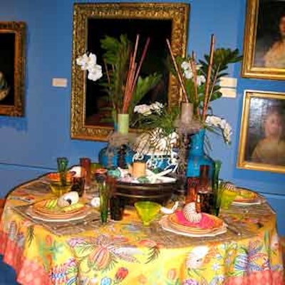 Colorful linens and bright dinnerware enhanced each place setting and tropical foliage set the mood at this table display.