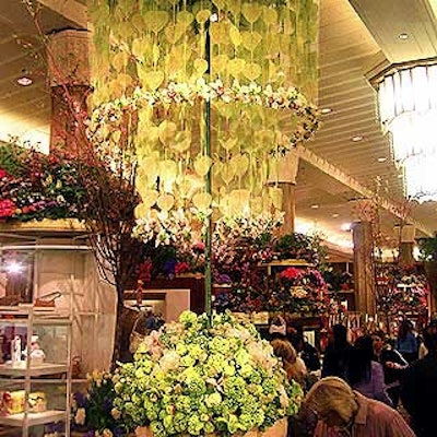 Preston Bailey created a lampshade-shaped piece that rose above a base arrangement of tulips, roses, peonies and hydrangeas. The towering shade was created using fragile natural leaves that were painted green and arranged in long strands, decorated with cymbidium orchids and viburnum.