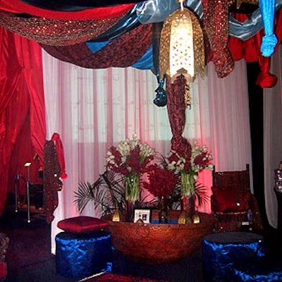 Susan Edgar of Flowers, Sticks and Stones draped red, silver, gold and blue fabrics from the ceiling of a Persian palace-themed room dedicated to Iranian author and journalist Azar Nafisi. White tulips, red orchids and potted ferns gave the room an exotic, romantic atmosphere.