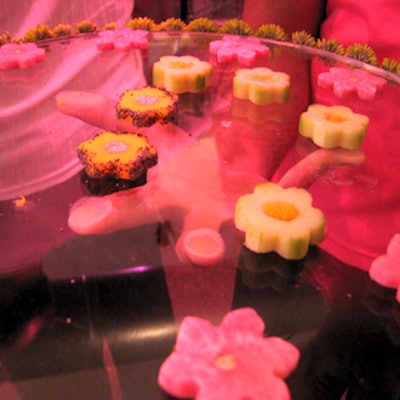 Caterwaiters passed cucumber, mango and watermelon radishes in the shape of blossoms on clear trays studded with green flowers along the edges.
