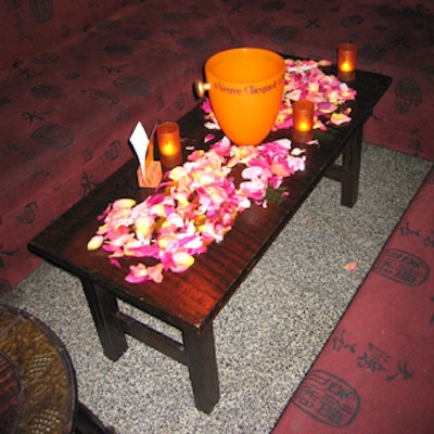 Dark wood tables were covered with pink flower petals and yellow Veuve champagne buckets.