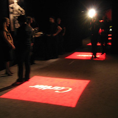 Square projections of red light with white Cartier logos in the center lined the entry to the main party space.