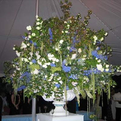 A gigantic arrangement of mountain laurel, blueberry bush, hybrid delphinium spears, white Casablanca lilies, white peonies, blue hydrangea and hanging amaranthus loomed over the guests.