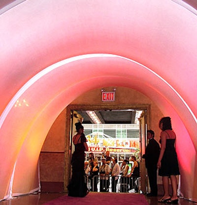 Guests entered the perfume-scented venue through an archway of pink- and peach-lit fabric, the event's primary decor colors.