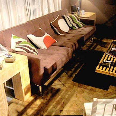 In the 'at home' room, a brown couch was flanked by wooden tables that held a Motorola cordless phone and a home entertainment center.