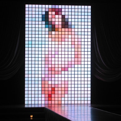 A tiled, lit screen displayed images of Lopez behind the runway.