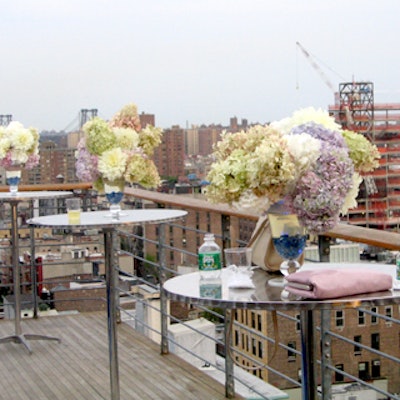 Silver cocktail tables topped with James Francois-Pijuan's pastel-colored floral arrangements covered the poolside deck.