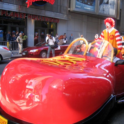 Ronald McDonald's shiny, red clown-shoe-shaped car led the procession down Broadway.