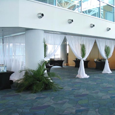 White draping adorned with foliage added a touch of elegance to individual sections of the event space.