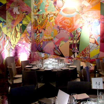 Decor for dinner in the Emily Fisher Landau dining room featured white chairs and black linens, with most of the color coming from blue uplighting by Bentley Meeker, a silent video projection by Slater Bradley, and a brightly colored wall mural by Assume Vivid Astro Focus.