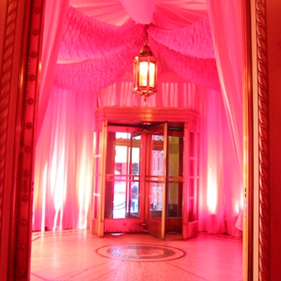 David Beahm Designs draped areas of the hall including the entrance with pink voile and diamond tufted pink velvet backdrops.