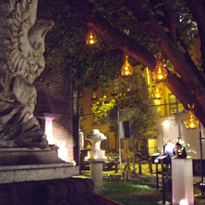 At the Elizabeth Street Gallery Sculpture Garden for Departures magazine's Italy issue, EventQuest suspended glass candleholders from tree branches.