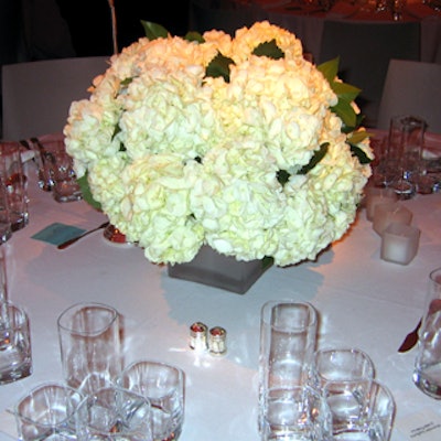 Plump bouquets of white hydrangeas set atop white tablecloths and illuminated by frosted white votive candles served as centerpieces at the Cooper-Hewitt National Design Museum's National Design Awards at the museum.
