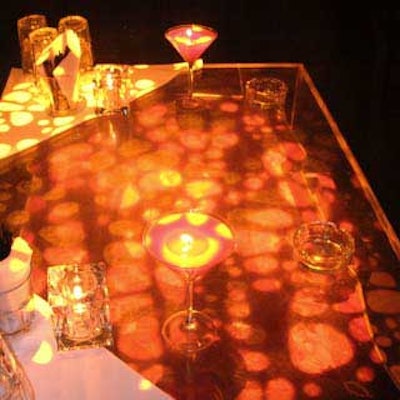 Projectors lit up tables with bubbly orange lights, creating the look of a Cointreau drink.