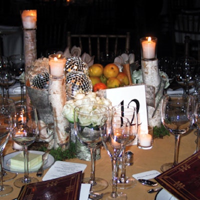 Tables featured large birch-bark containers filled with disco balls, pinecones, moss, pears, and mushrooms. Small bird's nests and birch log candleholders were tucked around the centerpieces.