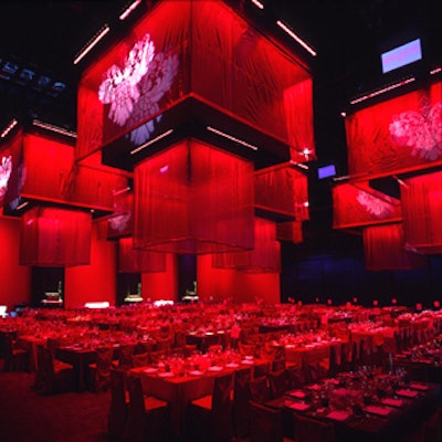 At the Louis Vuitton-sponsored United Cancer Front benefit at Universal Studios, the deep purple-carpeted dining room was lined with more than 60 red and aubergine fabric-cloaked rectangular tables. Seven 20-foot square cloth chandeliers hung from the ceiling. (Photo courtesy of J. Ben Bourgeois Productions)