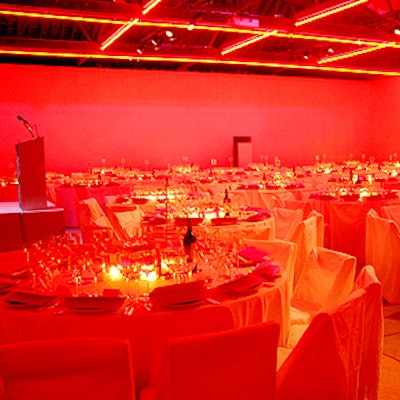 Dinner in Dia's Annex space was lit by a grid of Flavin-inspired red neon suspended from the ceiling. White walls, tablecloths, chair covers, and dinnerware reflected the red light, designed by Lite Brite Neon.