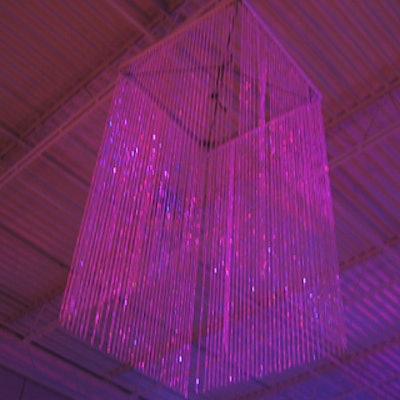 Innovative light-less chandeliers made of opalescent Lucite beads captured and reflected illumination from a laser show onto the bars and food stations.