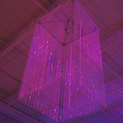 Innovative light-less chandeliers made of opalescent Lucite beads captured and reflected illumination from a laser show onto the bars and food stations.