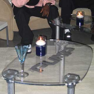Clear Lucite cocktail tables branded with the Pump logo in silver lettering were placed in a small lounge area.
