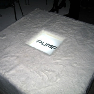 Fuzzy white cube seats with illuminated Pump logos in the center dotted the room.