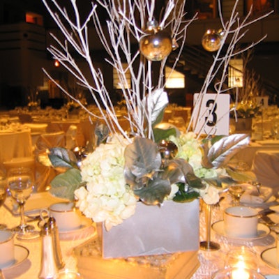 Florals from Avenue Flower enhanced the centerpieces by Evolving Events International, which included silver branches and ornaments atop glass blocks.