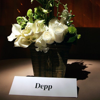 On the tables, name cards sat adjacent to mostly white flower arrangements.