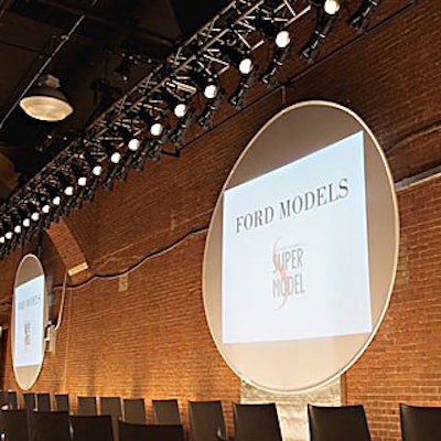 Models entered and exited the runway through doorways branded with the event's red, white, and black logo, and passed by two huge round video screens that displayed the logo.